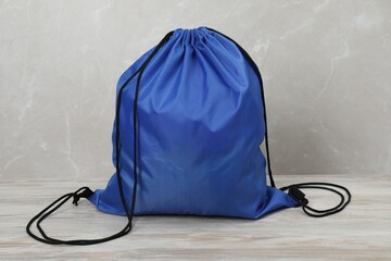 Blue drawstring bag on light wooden table