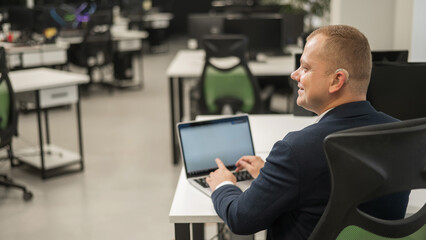 Caucasian deaf man typing on laptop in office. 