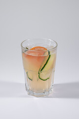 gin fizz cold ice cocktail with grapefruit and cucumber isolated on white