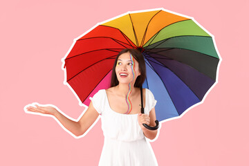 Young Asian woman with painted face and rainbow umbrella on pink background
