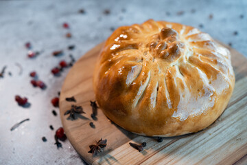 bread bowl with pilaf on wooden board and vegetables