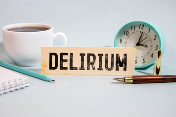 word delirium made of wooden letters on a gray table on a green background.