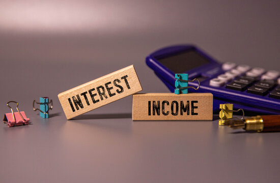 INTEREST INCOME text on notebook with pen on a chart background