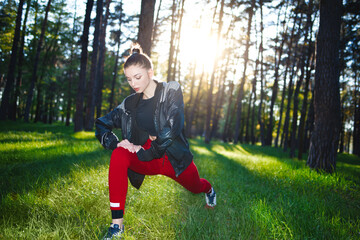 Athletic woman in tracksuit doing outdoor exercises in a park