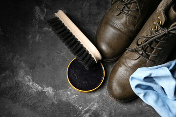 Shiny leather boots, brush, cloth and shoe polish on grey grunge background - Powered by Adobe