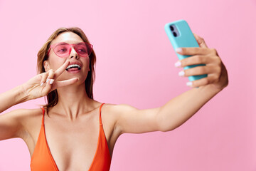 Captivating image of a glamorous woman in a vibrant swimsuit snapping a selfie on her phone against...