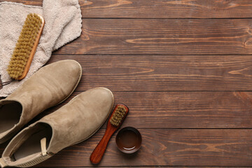 Brush, boots, cloth and shoe polish on wooden background
