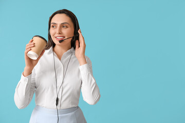 Female technical support agent in headset with paper cup of coffee on blue background