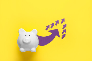 Piggy bank with arrows on yellow background. Price rise concept