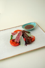 Striploin with grilled vegetables on a white background