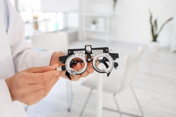 Female ophthalmologist with trial frame in clinic, closeup