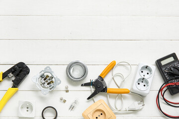 Electrician's tools and sockets  on white wooden background