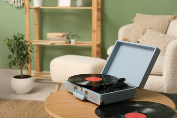 Record player with disks on coffee table in room