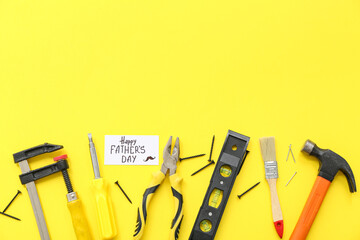 Tools and greeting card with text HAPPY FATHER'S DAY on yellow background