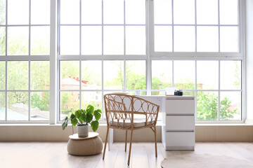 Table with photo camera near big window in room