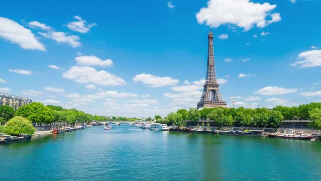 A timelapse of the Eiffel Tower along the river Seine with flyboats passing by with motion blur.Sunny but cloudy spring summer day paris city famous riverside bay tower view bridge timelapse panorama