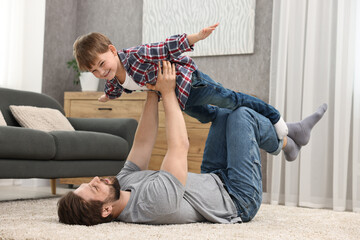 Happy dad and son having fun together at home