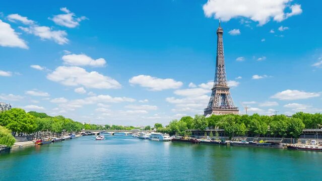 A timelapse of the Eiffel Tower along the river Seine with flyboats passing by with motion blur.Sunny but cloudy spring summer day paris city famous riverside bay tower view bridge timelapse panorama