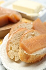 Delicious quince paste and bread on table, closeup