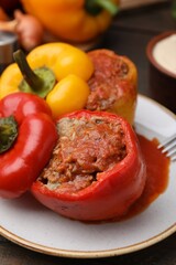 Delicious stuffed bell peppers served on wooden table, closeup