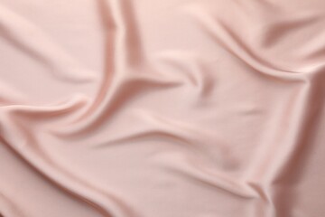 Crumpled pink silk fabric as background, top view