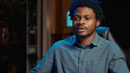 Happy african american man using gaming keyboard to play videogames at home. Gamer using powerful...