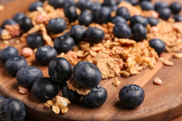 Sweet fresh blueberries and corn flakes on wooden background, closeup