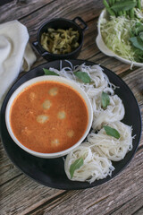 Rice noodles in a fish curry sauce with fish ball eat with vegetables. Traditional Thai food call 