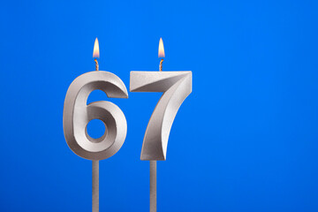 Birthday number 67 - Candle lit on blue background