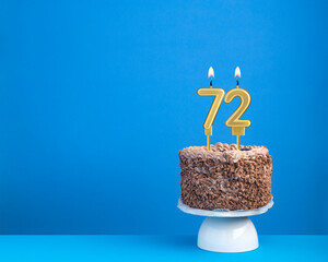 Birthday celebration with candle 72 - Chocolate cake on blue background