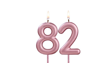 Candle number 82 - Lit birthday candle on white background