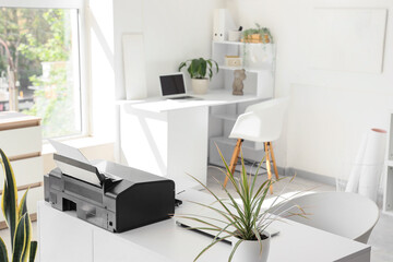 Modern printer on desk in light office