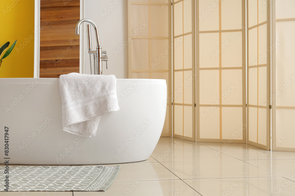 Poster Bathtub with towel in room