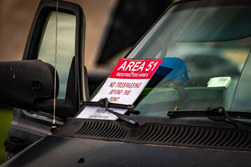 Funny area 51 sign on a car window.