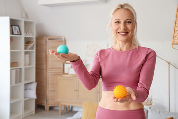 Sporty mature woman with massage balls at home