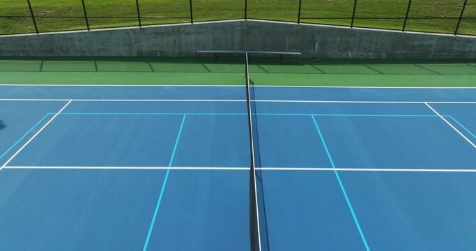 Drone, aerial, video over new blue tennis courts with white lines and light blue pickleball lines
