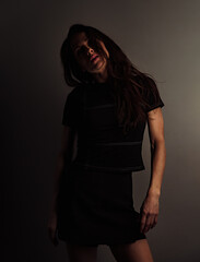 Beautiful sexy makeup woman looking with  long hair on the face in half shadow studio light. Closeup portrait. Art.Expression