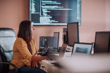 A businesswoman sitting in a programmer's office surrounded by computers, showing her expertise and...