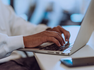 Close up photo of African American businessman is diligently working on his laptop, embodying determination, ambition, and productivity in his professional environmen