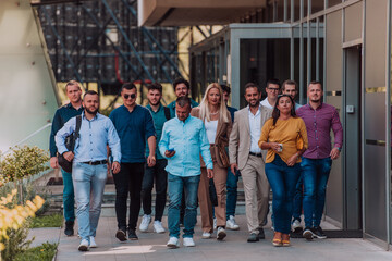 Obraz premium A diverse group of businessmen and colleagues walking together by their workplace, showcasing collaboration and teamwork in the company.
