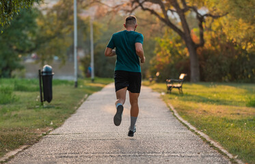 Athletic man running or jogging at the park active healthy lifestyle.