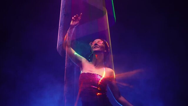 Beautiful woman dancing under colorful illumination, laser light, neon party night club. Performance, projection mapping. Interactive exposition installation.