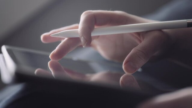 Close up of a graphic artist's hand rotating a drawing on a tablet. Slow motion. 