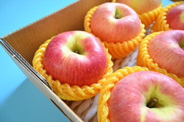 beautiful pink apple in the box on blue background