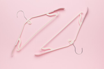 Minimalist White Plastic Clothing Hangers on Soft Pink Background