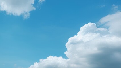 A clear blue sky with large, fluffy white clouds. The clouds are cumulus in shape, appearing soft...