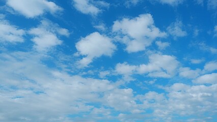 A vibrant blue sky dotted with fluffy white clouds, creating a picturesque and serene atmosphere....