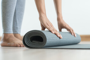 Hobby at home concept. woman rolling yoga mat off prepare to exercise in the morning