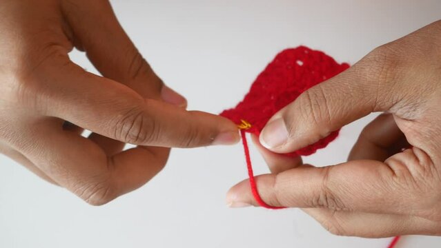 Hand close up crocheting with a hook, wool yarn, creative craft