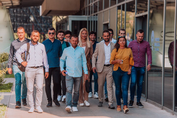 Obraz premium A diverse group of businessmen and colleagues walking together by their workplace, showcasing collaboration and teamwork in the company.